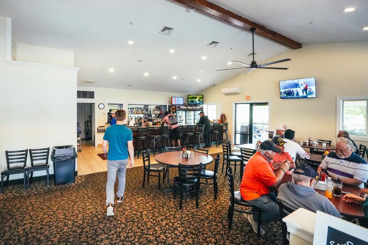 Casual Restaurant Interior with Bar and Seating Area People sitting at tables in a restaurant