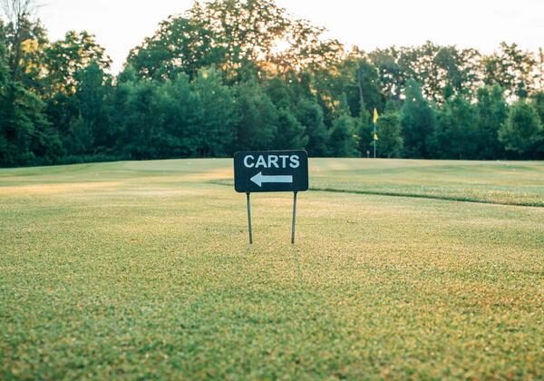 Golf Course Cart Sign A sign pointing to golf carts on a green course