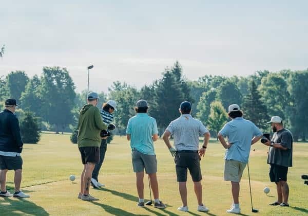 group of golfers on a driving range