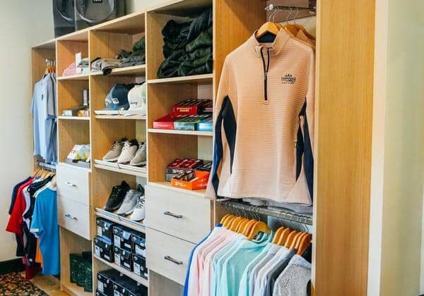 Walk-in closet with hanging clothes and shoes